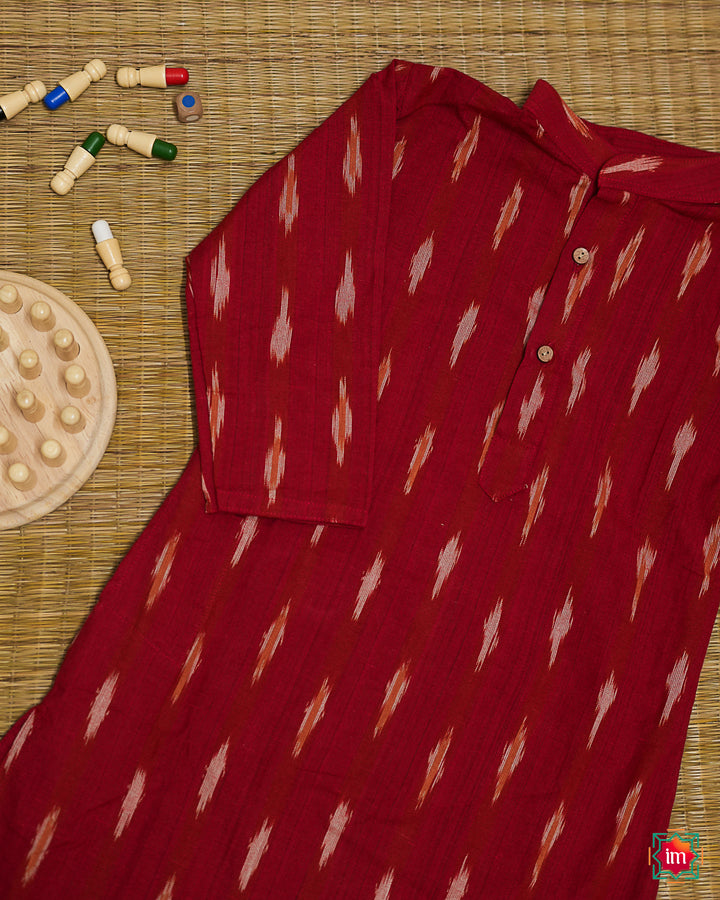 Beautiful red girl kurta which is kept on a mat background with some children indoor games which are kept beside.