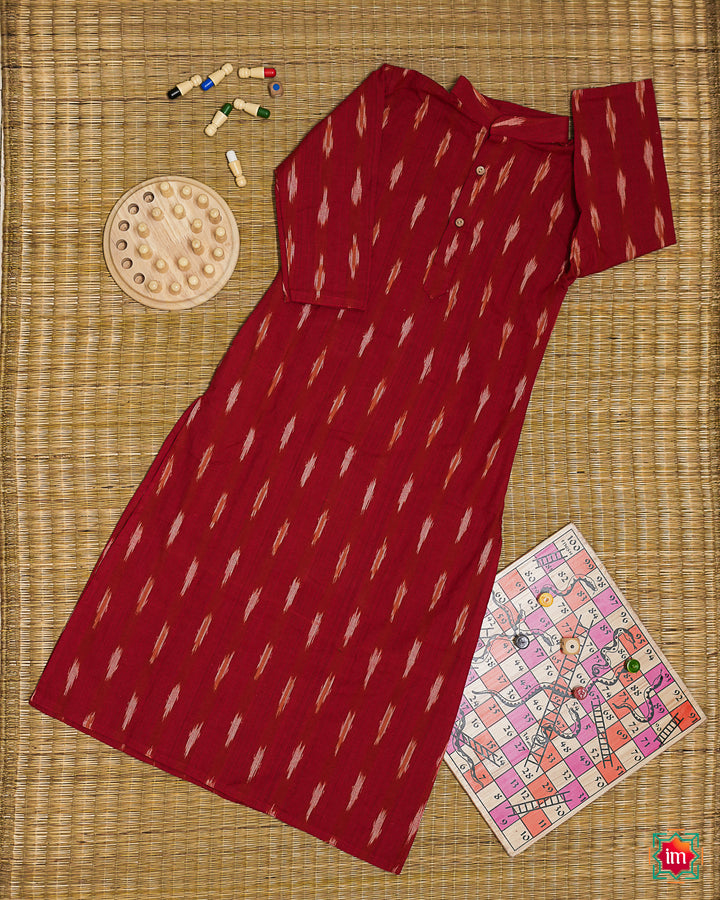 Beautiful red girl front kurta which is kept on a mat background with some children indoor games which are kept beside.