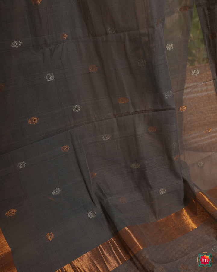 Grey handloom cotton saree, where in the detailed saree print is displayed.