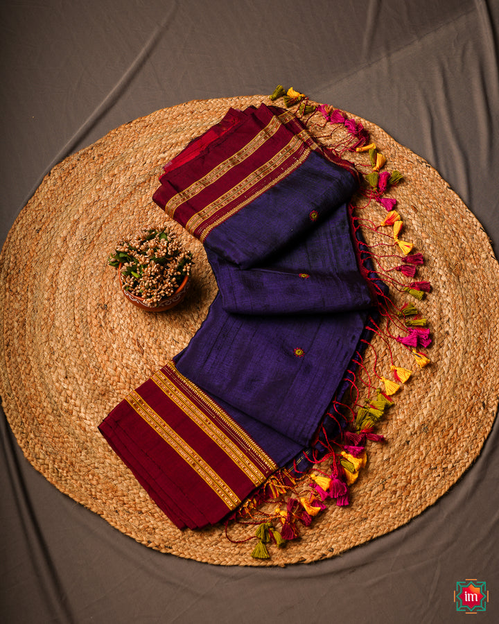 Purple saree is kept on a jute mat.