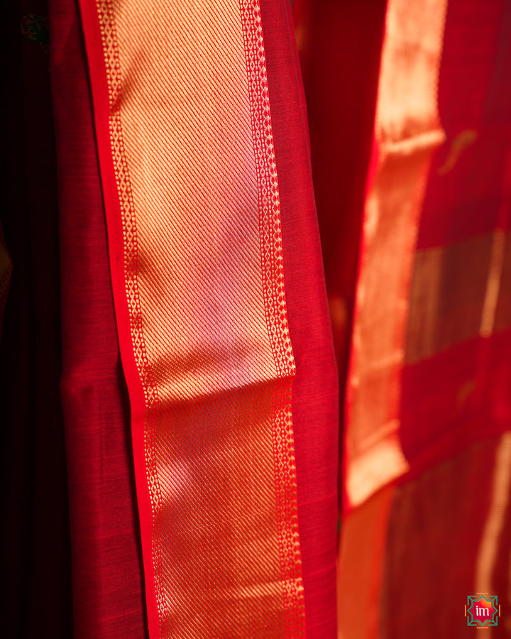 Elegant red hadloom cotton saree, where in the detailed saree print is displayed.