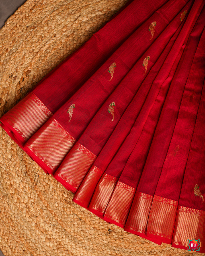 ﻿Elegant red handloom cotton saree is pleated and displayed on the floor.