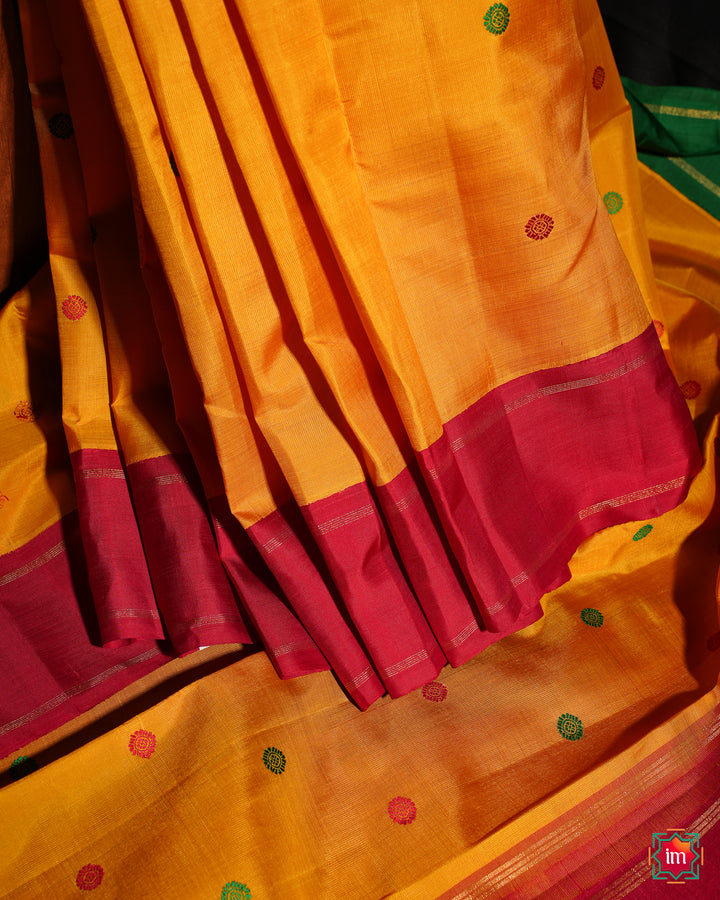 Yellow Red Ganga Jamuna Kanjivaram silk saree is pleated and displayed.